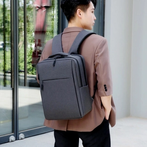 Modern dark grey business backpack for men shown on model with wide shoulder straps