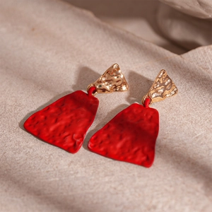 Detail showing the hammered texture of vintage red and gold geometric earrings