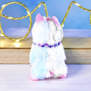 Macro view of a soft rainbow cat plush keychain with a cute purple beaded collar detail