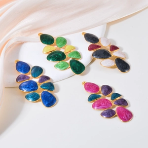 Colorful enamel leaf earrings in teardrop shape with gold finish on pink silk backdrop