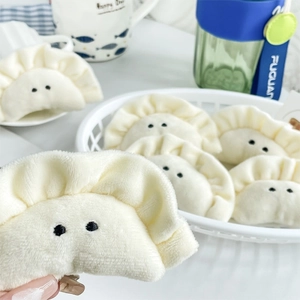 Cute white dumpling plush keychain made of soft fabric hanging on a storage basket