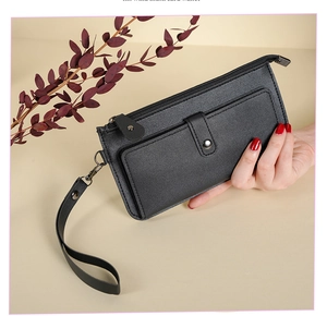 Macro shot of black long leather wallet with secure metal zipper and detachable wrist strap