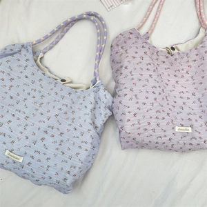 Détail de sacs fourre-tout en mousseline fleurie bleu et lavande avec anses en corde