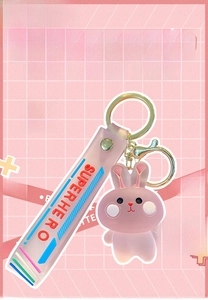 Détail du porte-clés lapin rose avec fermoir doré et dragonne rose superhero