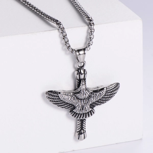 Macro shot of silver eagle pendant showing detailed feather texture and box chain
