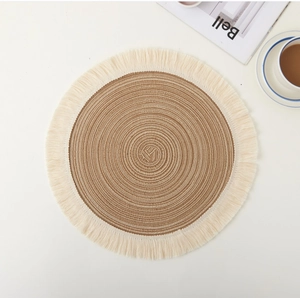 Close-up of a Nordic round jute placemat with brown spiral texture and beige tassel fringe