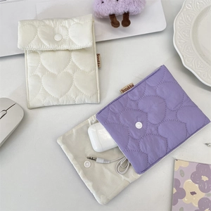 Quilted heart pouch detail showing metal snap closure and soft fabric texture