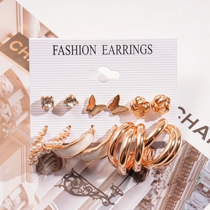 Detailed set of gold earrings with pearls, crystals, and butterfly motifs on a card