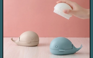 Detailed view of cute whale-shaped laundry brushes with soft bristles in three colors