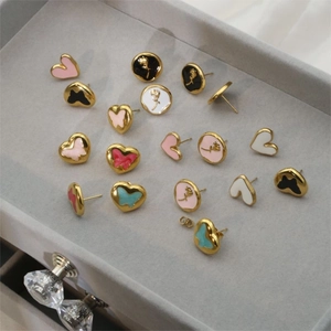 Élégantes boucles d'oreilles fleurs et papillons en émail doré sur plateau de velours
