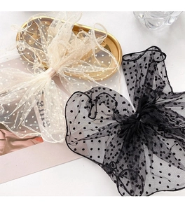 Detail shot of elegant polka dot mesh bow hair clips on a golden decorative tray