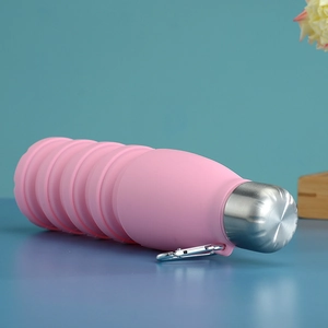 Detailed view of pink collapsible silicone water bottle with metal cap and carabiner