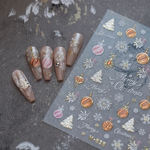 Christmas nail art stickers with gold snowflakes and trees on dark background