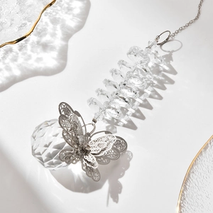 Hanging suncatcher with silver metal butterfly and faceted crystal ball on white background
