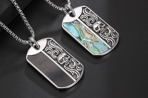 Detailed macro view of dual titanium necklaces with skull and flame shell inlay
