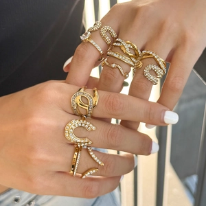 Titanium steel gold rings with zircon stones shown on hand in outdoor natural light