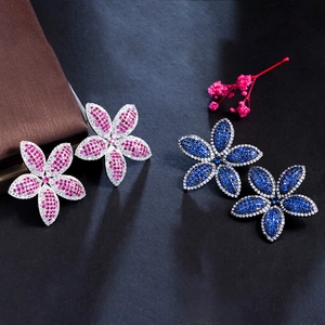 Detailed view of floral zircon earrings with pave setting in pink and blue stones