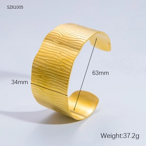 Detailed macro view of 34mm wide gold cuff bracelet with natural wood grain texture