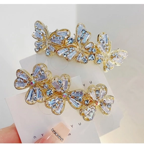 Detailed macro view of crystal bow and flower hair clips in gold finish for women