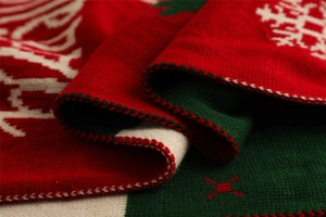 Close-up of red and green knit fabric featuring Christmas snowflake and geometric patterns
