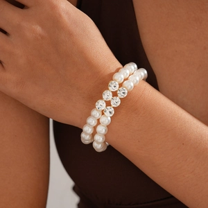 Detail view of a double-layer pearl bracelet with a sparkling crystal-set gold-tone clasp