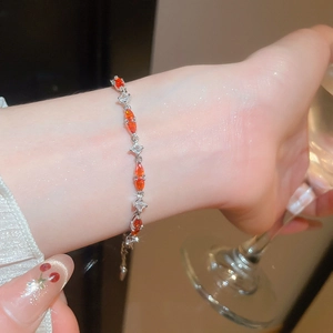 Detail of silver bracelet with marquise-cut orange and clear zircons on wrist