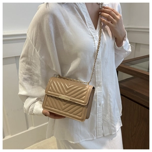 Detail of khaki quilted cross-body bag with V-shaped stitching and gold chain strap