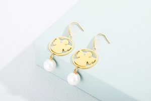 Detailed view of gold angel silhouette earrings with elegant white pearl pendant charms