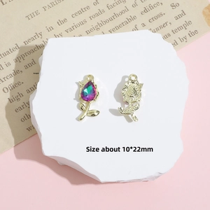 Detail view of tulip-shaped gold charm with gradient gemstone on white stone