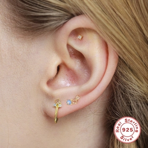 Detail of 925 sterling silver ear cuff set with blue and pink gems on model ear