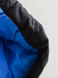 Vue macro des coutures contrastées et de la texture du tissu sur une veste sans manches
