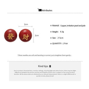 Détail des boucles d'oreilles émaillées rouges avec caractères chinois dorés chance