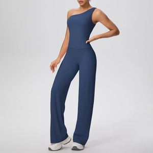Détail d'un haut de yoga à une épaule et d'un pantalon large bleu marine sur modèle