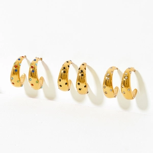 Three pairs of gold C-shaped stainless steel earrings with colorful zircon stones on white background