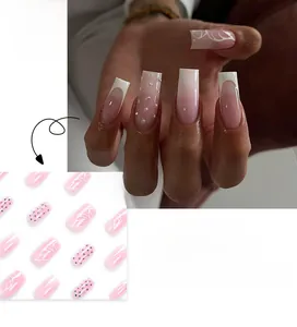Close-up of French press-on nails with pink gradient, white tips, and delicate rhinestones