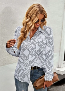 Close-up of white long sleeve shirt featuring black paisley print and front pocket detail