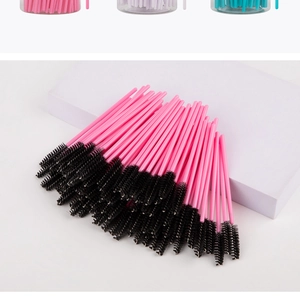 Detail of disposable spiral eyelash brushes with pink handles and black synthetic bristles