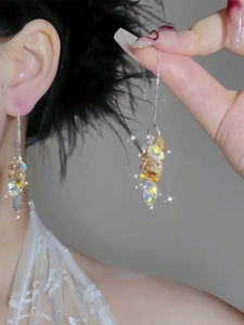 Close-up of long tassel earrings with sparkling champagne crystal beads on model