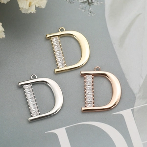 Three colors of D-letter pendants in gold, silver, and rose gold with baguette zircons