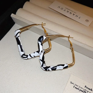 Detailed view of square geometric earrings with leopard print resin in golden frame