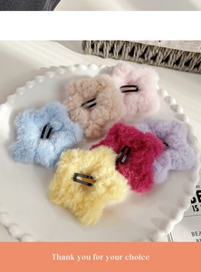 Set of six colorful plush star hair clips displayed in a white ceramic dish