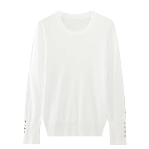 Detail of white long sleeve knit top featuring elegant golden buttons on the cuffs