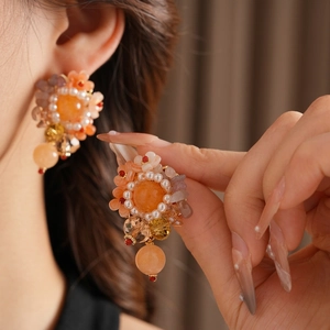 Luxury floral pearl pendant earrings with warm orange stones for a high-end fashion look