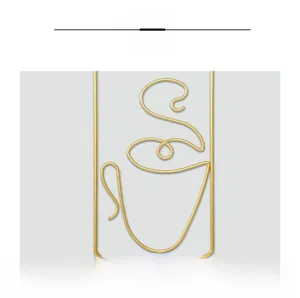 Detail of minimalist gold metal coffee cup wall art with polished wire finish