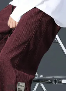 Close-up of wine red corduroy cargo pants with 01 Good Ideas decorative patch detail