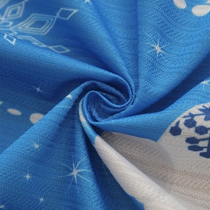 Close-up of blue blackout curtain fabric with white snowflake and star floral pattern