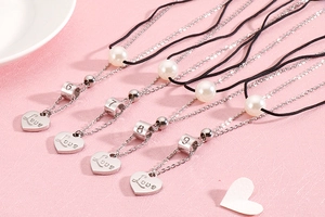 Detail of heart pendants and pearls on double-layer stainless steel necklaces
