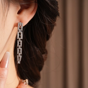 Gros plan de boucles d'oreilles pendantes en argent avec zircons brillants sur un mannequin