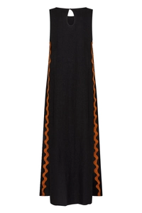 Detail view of scalloped orange trim and drop-shaped back cutout on black dress