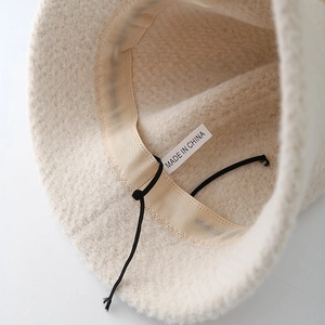 Plush bucket hat with adjustable inner drawstring and breathable sweatband detail